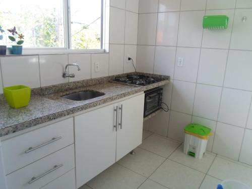 弗洛里亚诺波利斯Apartmento Praia da Armação -Sul da Ilha的厨房配有水槽和炉灶