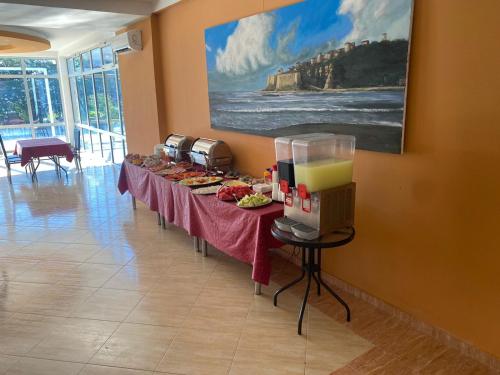 乌尔齐尼Vila Kollari的一间有食物的房间的一排桌子