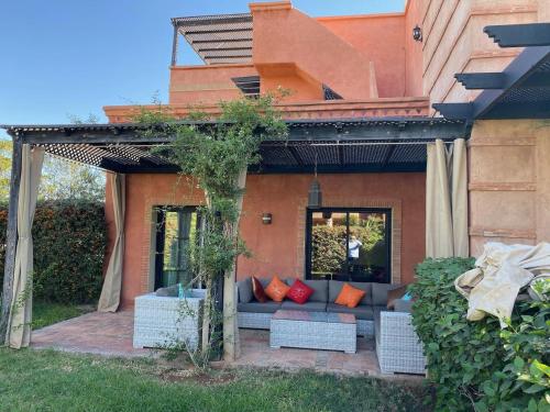 马拉喀什atlas golf resort marrakech " Maison à 03 chambres avec jardin privé "的房屋前方的天井(带沙发)