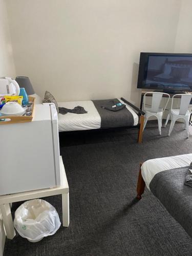 蒙塔Cornwall Hotel的客房设有两张床和一台平面电视。