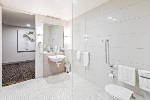 布里斯班考尔姆斯里酒店的白色的浴室设有水槽和卫生间。