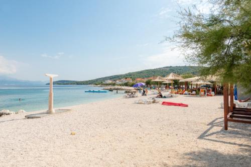斯拉汀Apartments by the sea Slatine, Ciovo - 1137的海滩上设有椅子和遮阳伞,还有大海
