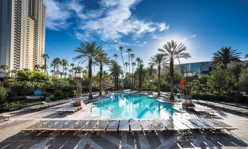 拉斯维加斯MGM格兰德天空公寓酒店的度假村的游泳池,带躺椅和棕榈树