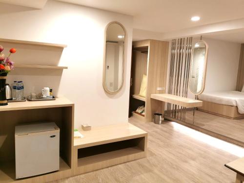 合艾撒库尔酒店的客房设有带一张床和镜子的卧室