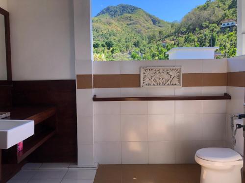 艾湄湾Meditasi Bungalows & Villas的一间带卫生间的浴室和山景窗户。