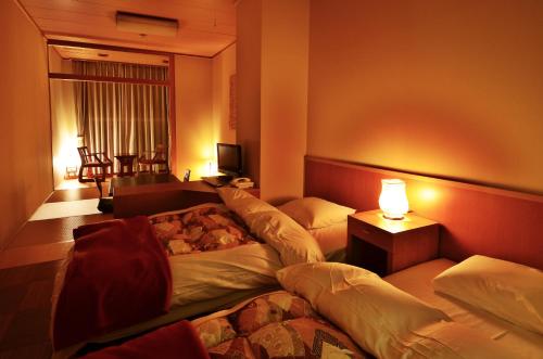三好市太阳河大步危酒店的酒店客房设有两张床和一张桌子。