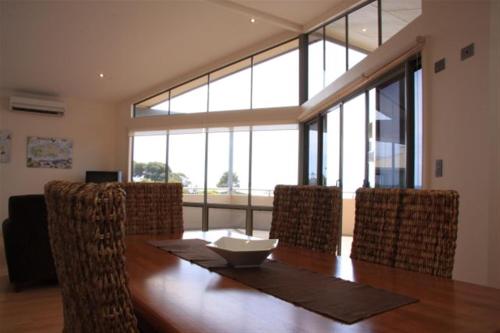 Emu BayBirubi Holiday Homes Kangaroo Island的一间带木桌和椅子的用餐室
