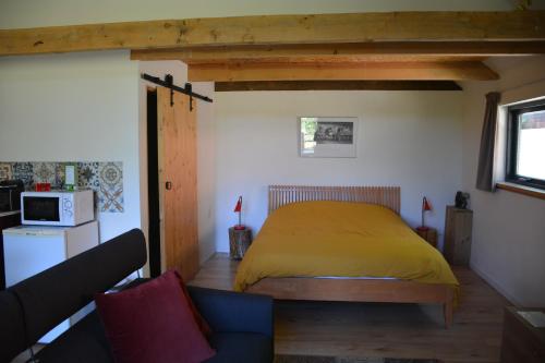 HaarenTijdzat的卧室里设有一张黄色的床