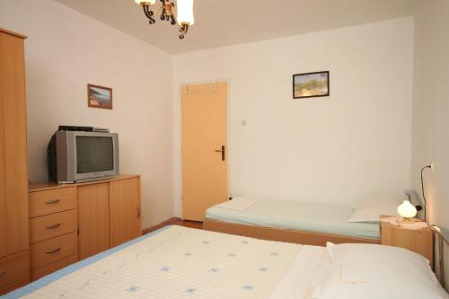 苏库拉伊Triple Room Sucuraj 6734c的一间带两张床和电视的小卧室