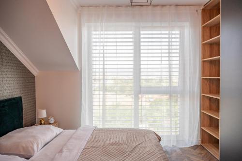 波切尼斯Apartmány pod Zámkom的一间卧室设有一张床和一个大窗户