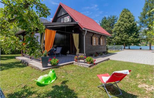 奥古林Lovely Home In Ogulin With Wifi的一座红色屋顶的房子和一个带椅子的庭院