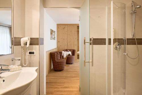 塞尔瓦迪加尔代纳山谷Hotel Comploj Adults only的带淋浴和盥洗盆的浴室