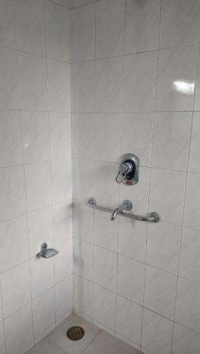 德拉敦vera home stay的带淋浴的浴室和白色瓷砖墙壁
