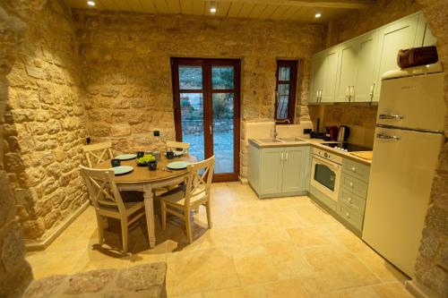 艾拉方索斯Harmony Seaview Villas In Elafonisos的厨房配有桌椅和冰箱。