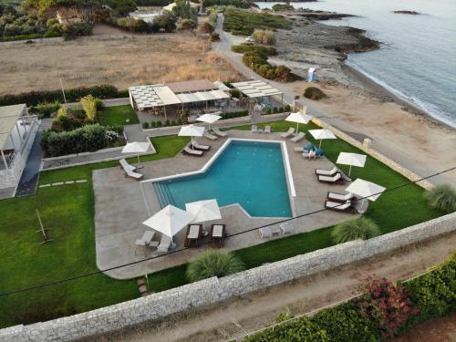 马拉松波利斯Callisto Seaside Homes & Suites的享有带椅子和遮阳伞的游泳池的上方景色