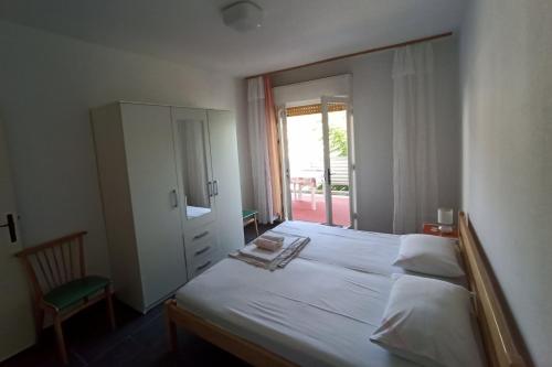 苏佩塔斯卡德拉加Apartments by the sea Supetarska Draga - Donja, Rab - 5042的卧室配有一张带镜子的白色大床