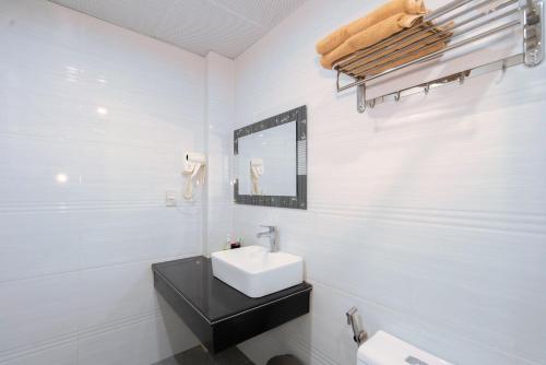 下龙湾De Charm Hạ Long Hotel的白色的浴室设有水槽和镜子
