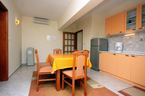 拉布Apartments with a parking space Kampor, Rab - 5018的厨房配有一张带黄桌布的桌子