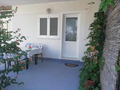 马拉诺维奇Apartments by the sea Cove Saplunara, Mljet - 4896的一个带桌子和白色门的庭院