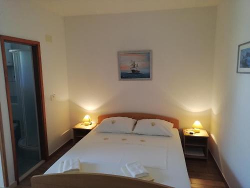 马拉诺维奇Apartments by the sea Cove Saplunara, Mljet - 4896的卧室配有白色的床和两盏灯。