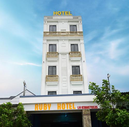 Hoi NghiaRuby Hotel - Tân Uyên - Bình Dương的白色的建筑,上面有酒店标志