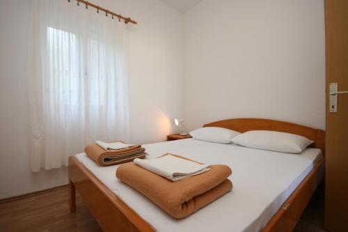 格拉达茨Apartments with a parking space Gradac, Makarska - 6724的一间卧室配有带毛巾的床