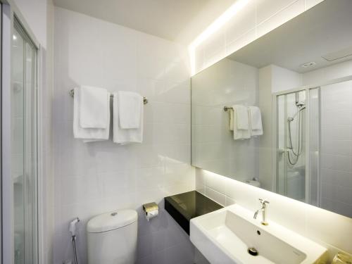 占那县Kitzio House Hotel Huai Kwang的一间带卫生间、水槽和镜子的浴室