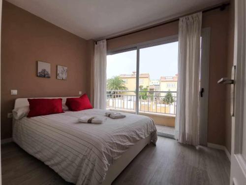梅莱纳拉Apartamento en la Playa的一间卧室配有一张带红色枕头的床和大窗户