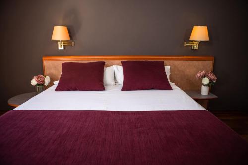 卡尔德斯德蒙特维RVHotels Spa Vila de Caldes - Adults only的一间卧室配有一张大床,提供紫色床单和枕头