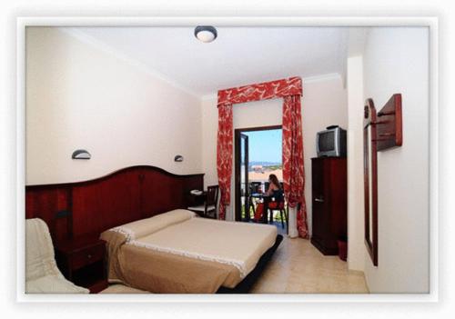 卡拉赛达斯特拉德尔苏德酒店的一间卧室设有一张床、一个窗口和一台电视
