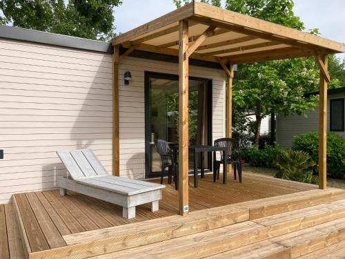 乌尔坦Cottage 2 pers KEY WEST Premium的木制凉棚,配有桌子和甲板上的长凳