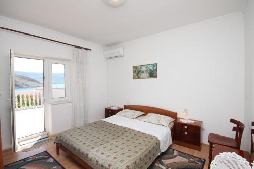 梅塔伊纳Apartments and rooms by the sea Metajna, Pag - 6496的一间卧室设有一张床和一个大窗户