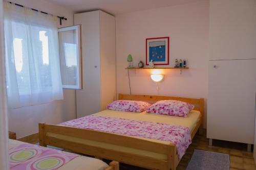 斯托莫斯卡Apartments by the sea Stomorska, Solta - 5190的一间卧室设有两张床和窗户。