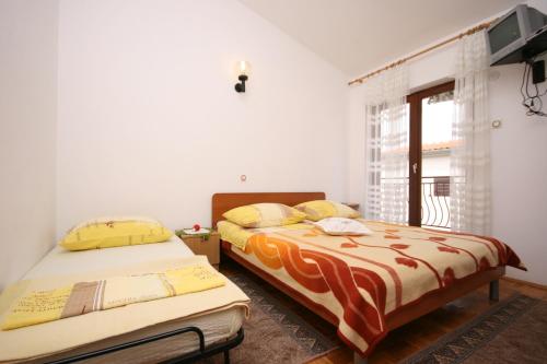 斯塔利格拉德-帕克利尼卡Apartments by the sea Starigrad, Paklenica - 6579的一间卧室设有两张床和窗户。