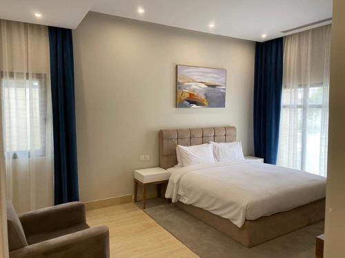半月湾Half Moon Al Khobar Resort的一间卧室配有一张床和一把椅子