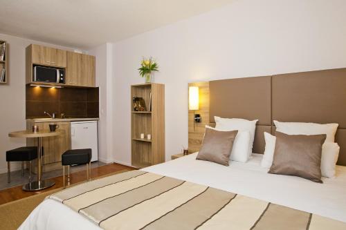斯特拉斯堡塞祖尔阿菲尔斯塔伯格克雷贝酒店的酒店客房设有一张大床和一个厨房。