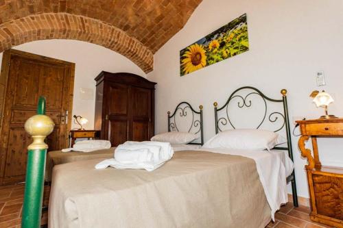 莫夏诺圣安杰洛BB Casale La Selva Mosciano的一间卧室配有两张带白色床单的床