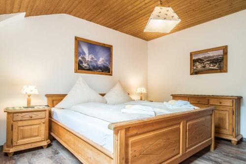 奥博奥多夫奥多夫乡村度假酒店的卧室配有一张带白色床单和木制家具的大床