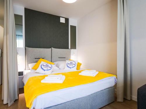科沃布热格MK Apartamenty Młyńska 10的一间卧室配有一张大床和两条毛巾