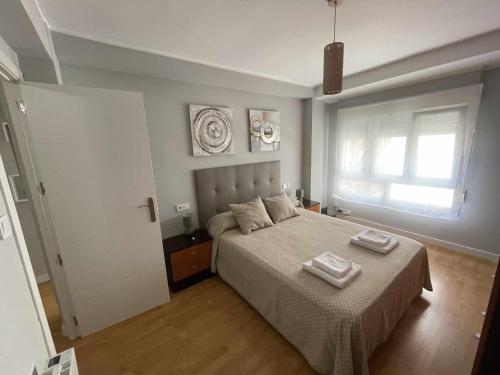 希洪Arena Playa Gijón by Flowhome的一间卧室配有一张床,上面有两条毛巾