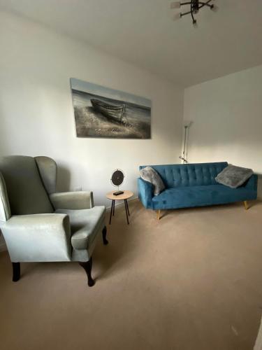 麦斯堡Kingfisher House的客厅配有蓝色的沙发和椅子