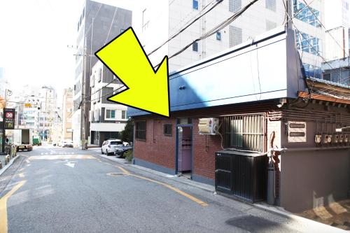 首尔Ellen House的城市街道上一座建筑物上的黄色箭头标志