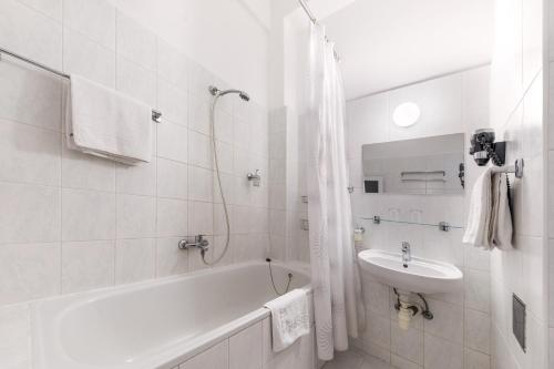 布拉格坎帕梅达博物馆酒店的白色的浴室设有浴缸和水槽。