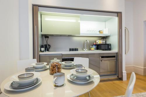 伦敦The Dorset Suite - Stylish New 1 Bedroom Apartment In Marylebone的厨房配有带餐具的桌子