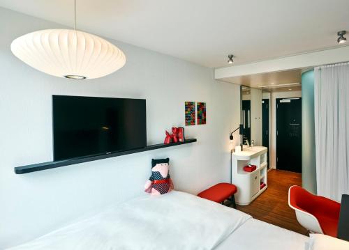 迈阿密citizenM Miami Brickell的卧室配有一张床,墙上配有电视。