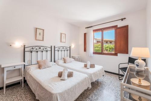 阿尔库迪亚Villa Tacaritx的白色客房的两张床,设有窗户