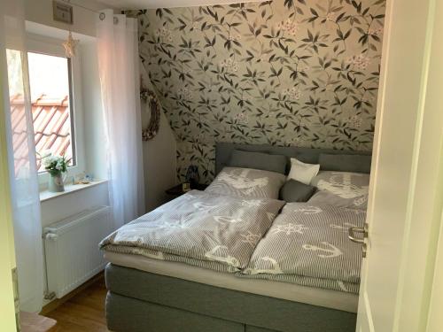 伦茨堡FeWo "Zwischen den Meeren"的一间卧室配有一张带花卉壁纸的床
