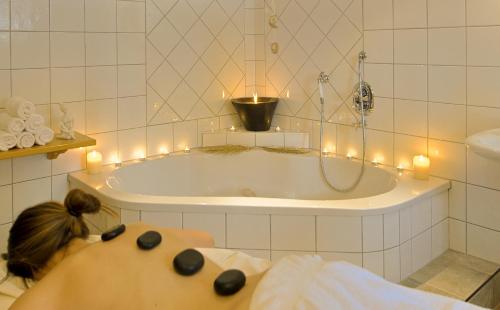 拉德施塔特罗马少年酒店的躺在浴缸前的女宾,有灯