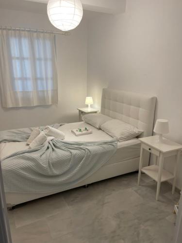 帕诺尔莫斯Amedi Villas Tinos的白色卧室配有床和桌子