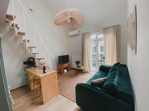 波兹南Nadolnik apartment的客厅设有绿色沙发和楼梯。
